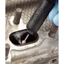 A gloved hand holds a Draper Spare 80 Grit Round Grinding Point For 95W Multi-Tool Kit - APT59A with a pink abrasive tip inside a metal engine component with visible threaded bolts.