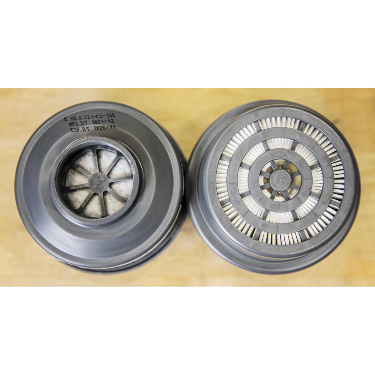 Top view of two cylindrical Sealey A2P3R Filter Cartridges (Pack of 2, product number 9366) on a wooden surface, one featuring a visible filter element for organic vapor protection and the other embellished with a circular pattern of metallic fins.