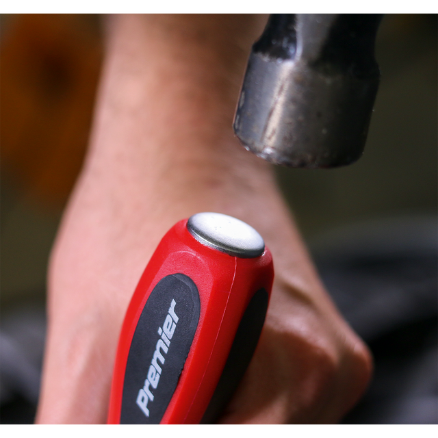 Close-up of a hand holding a red-handled screwdriver from the Sealey Screwdriver Set 6pc Hammer-Thru - AK4932, featuring a metal cap and Chrome Vanadium steel construction, with a hammer poised above it, indicating impact; this high-quality tool is supported by Sealey's lifetime guarantee.
