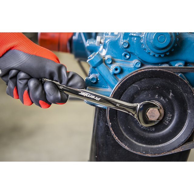 A gloved hand from the Sealey Combination Spanner Set 12pc - Metric - AK63265 uses a wrench to tighten a bolt on a mechanical assembly, showcasing the reliable strength of chrome vanadium steel.