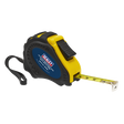 A Sealey Auto Lock Tape Measure 3m(10ft) x 16mm - Metric/Imperial (AK993) with a high-visibility black and yellow composite case, dual Metric and Imperial scales, and a wrist strap; the extending yellow measuring tape is partially pulled out.