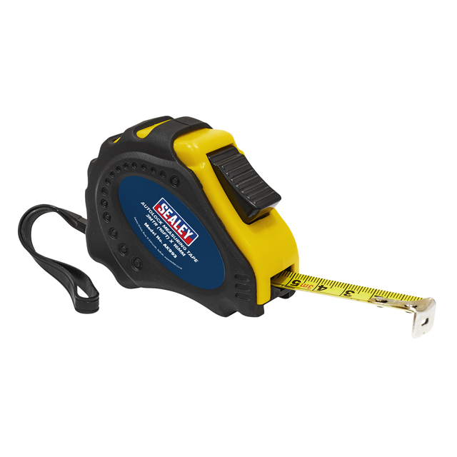 A Sealey Auto Lock Tape Measure 3m(10ft) x 16mm - Metric/Imperial (AK993) with a high-visibility black and yellow composite case, dual Metric and Imperial scales, and a wrist strap; the extending yellow measuring tape is partially pulled out.