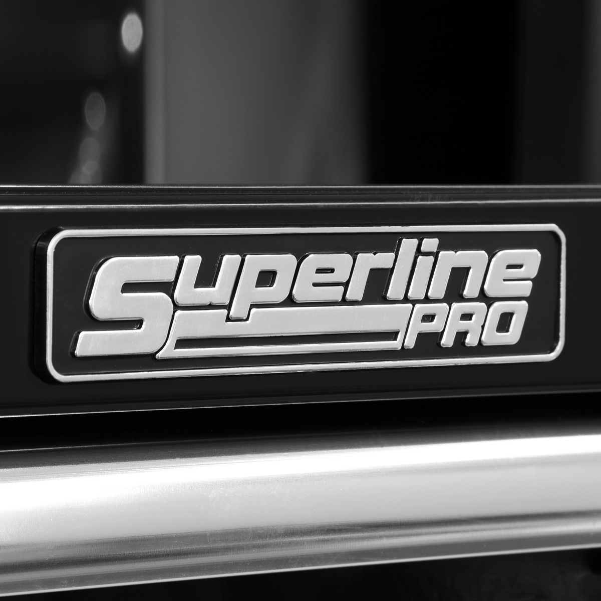 Close-up of a sign displaying the logo "Topchest 14 Drawer with Ball-Bearing Slides Heavy-Duty - Black - AP41149B" in metallic letters on a dark background, highlighting its durable steel construction by Sealey.