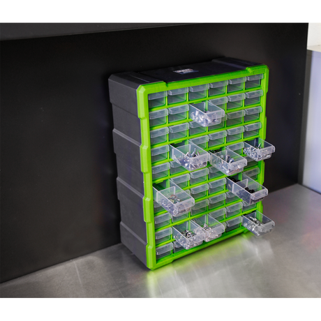 The Sealey Cabinet Box 60 Drawer - Green/Black - APDC60HV, a black and green plastic storage cabinet with impact-resistant, transparent drawers, is perfect for storing fixings and components. It is mounted on a wall above a metallic work surface.