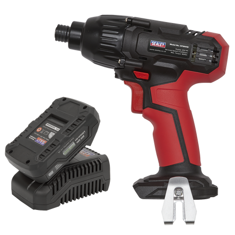 The Sealey Impact Driver Kit 1/4" Hex Drive 20V 2Ah from the SV20 Series (CP20VIDKIT1) in red and black is placed next to a battery pack and charger. The impact driver features an ergonomic handle and Sealey branding on the side, making it a standout addition to any toolkit.