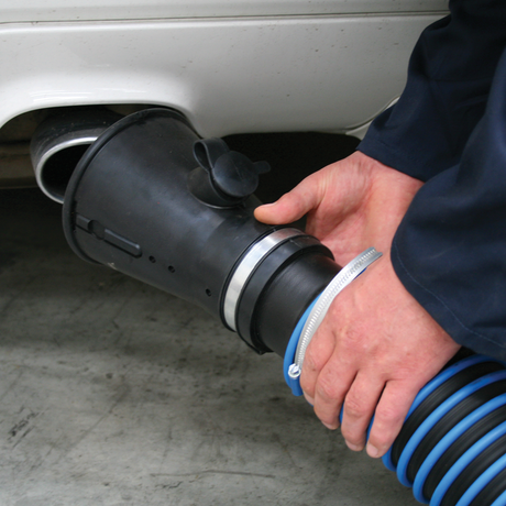 A person attaches a Sealey Exhaust Fume Extractor with 6m Ducting (EFS/93) to the exhaust pipe of a vehicle, using gas analyser probes to ensure accurate readings.