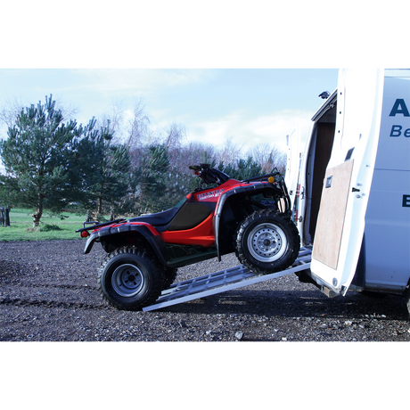 A red ATV is being loaded into a white van using the Sealey Motorcycle/Trike/ATV & Mini Tractor Ramp Wide Tri-Fold 680kg Capacity (FLR680T), set against a background of trees and a gravel surface.