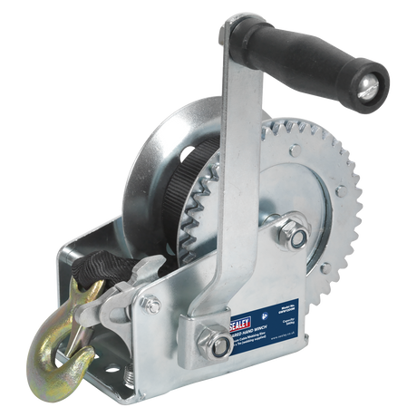 The Sealey Geared Hand Winch 540kg Capacity with Webbing Strap - GWW1200M features a crank handle, steel gear mechanism, and hook, commonly used for lifting or pulling heavy loads in recovery operations.
