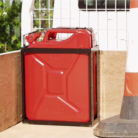 A Sealey Vehicle Bracket for JC20, JC20B, JC20G - JC20VB secures a red 20L jerry can on the back of a vehicle, next to a traffic cone and a metal mesh divider.