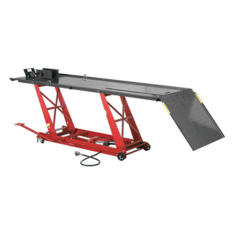 The Sealey Motorcycle Lift MC401A, with a 454kg capacity, features a vibrant red design and diamond plate surface. It includes an air/hydraulic lifting system, wide ramp for easy access, and integrated safety lock device.