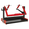 The Sealey Motorcycle Engine Stand - Single/Twin Cylinder - MES01 is a red and black mechanical device featuring adjustable arms, a rectangular base, and an integrated utility tray, designed for securely mounting or holding objects in place.
