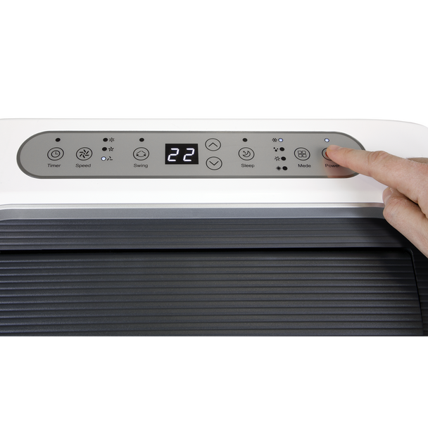 Hand adjusting the temperature on an air conditioner control panel.
