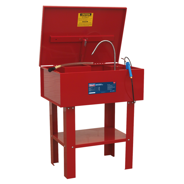 The Sealey SM22 Parts Cleaning Tank Air Operated is designed for hazardous environments, ensuring durability and safety for tough cleaning jobs. This heavy-duty red parts washer features an open lid with a warning label inside, a flexible nozzle, and a cleaning brush. The welded steel tank stands on four sturdy legs with a lower shelf for added convenience.