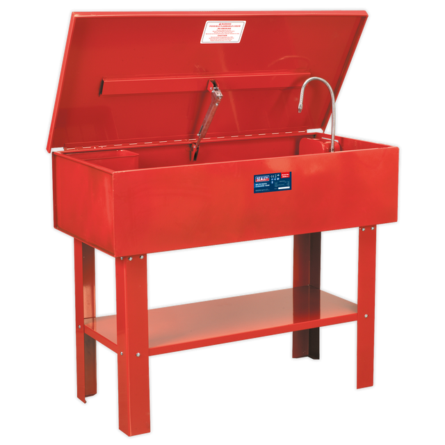 The Sealey Parts Cleaning Tank - SM40 is a red metal washer featuring an open lid, a cleaning nozzle, and a front label. It boasts a large capacity tank and is supported by four sturdy legs. This washer also comes with a triple-baked enamel finish for enhanced durability.