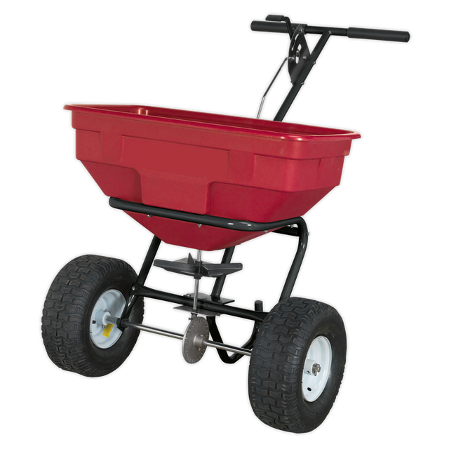 The Sealey Broadcast Spreader 57kg Walk Behind - SPB57W features a red and black design, metal frame, heavy-duty pneumatic tires, an adjustable feed system, and two handles.