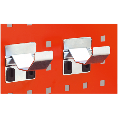 Two Sealey Pipe Brackets Ø60mm from the TTS24 pack of two are mounted on an orange PerfoWall panel, each holding a black plastic accessory behind the bracket.