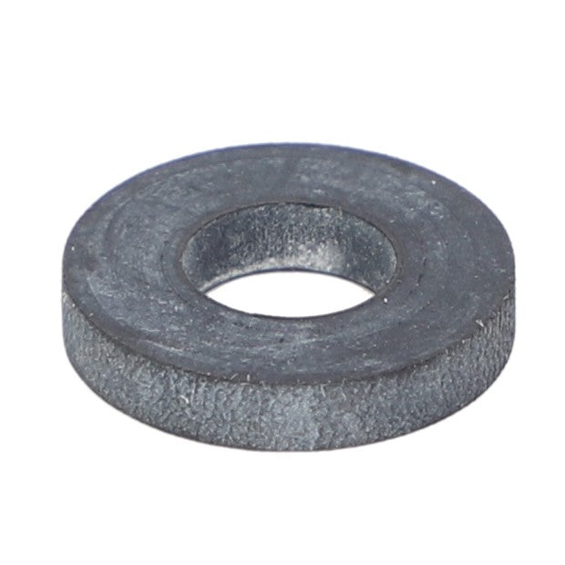 A close-up image of the AGCO Gasket - Ag006063, a dark, flat, round metal washer with a central hole, commonly used in engineering and construction.