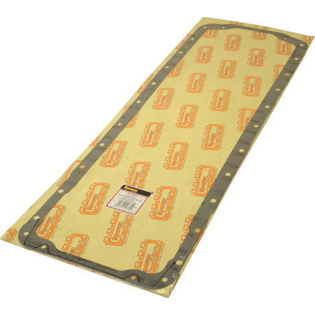 A rectangular Sparex Sump Gasket (320D, 320DS, 66CTA-4J, 645DSBAE, 620DW, 620D, 620DS, 634DS) laid on a cellulosic fibre board backing printed with a repeating Valmet & Valtra logo pattern. A label with a barcode is attached to the center.