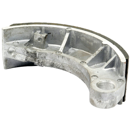The Sparex Brake Shoe (1 pc.) | Sparex Part No. S.68787, crafted from aluminum, features a curved, grooved design with a cylindrical mounting hole and durable brake lining, making it compatible with Zetor models.