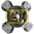 Close-up image of a metal clutch plate with four pads and springs, marked with text in Cyrillic script and visible part numbers. The background features a semi-transparent yellow logo overlay. The detailed shot reveals the spline design, enhancing the functionality of this Sparex component - Clutch Plate (S.156483).