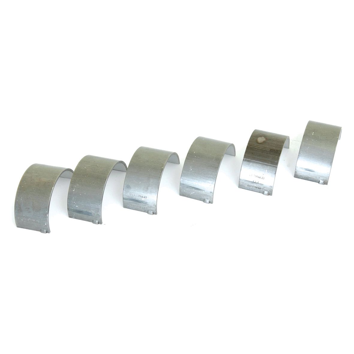 Six Sparex Conrod Bearing +0.010'' (0.25mm) Sets (Part No. S.65195), compatible with New Holland and Ford tractors, are arranged in a line, each semi-circular silver metallic shell displaying minor surface wear.