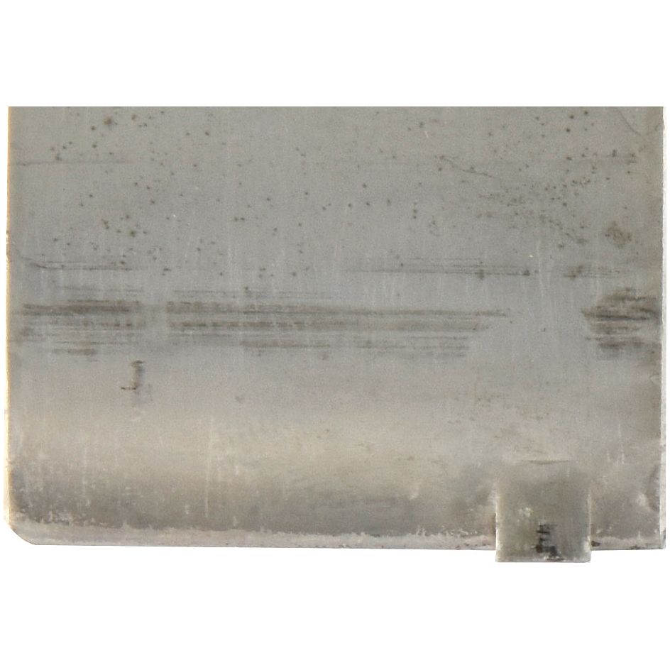 Close-up view of a metallic surface with scratches and small spots of wear and tear, reminiscent of a vintage Landini tractor, showing a notched corner at the bottom right. Featured part: Conrod Bearing Std. Set | Sparex Part No.S.42972 by Sparex.