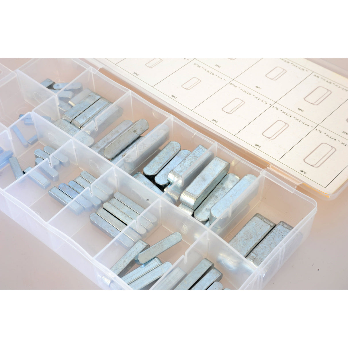 The Sparex Imperial Parallel Keys Assortment, 60 pcs. Compak (Part No. S.29902) is a plastic organizer box that contains various sizes of zinc balancing weights divided into compartments, with a diagram sheet placed underneath the lid.