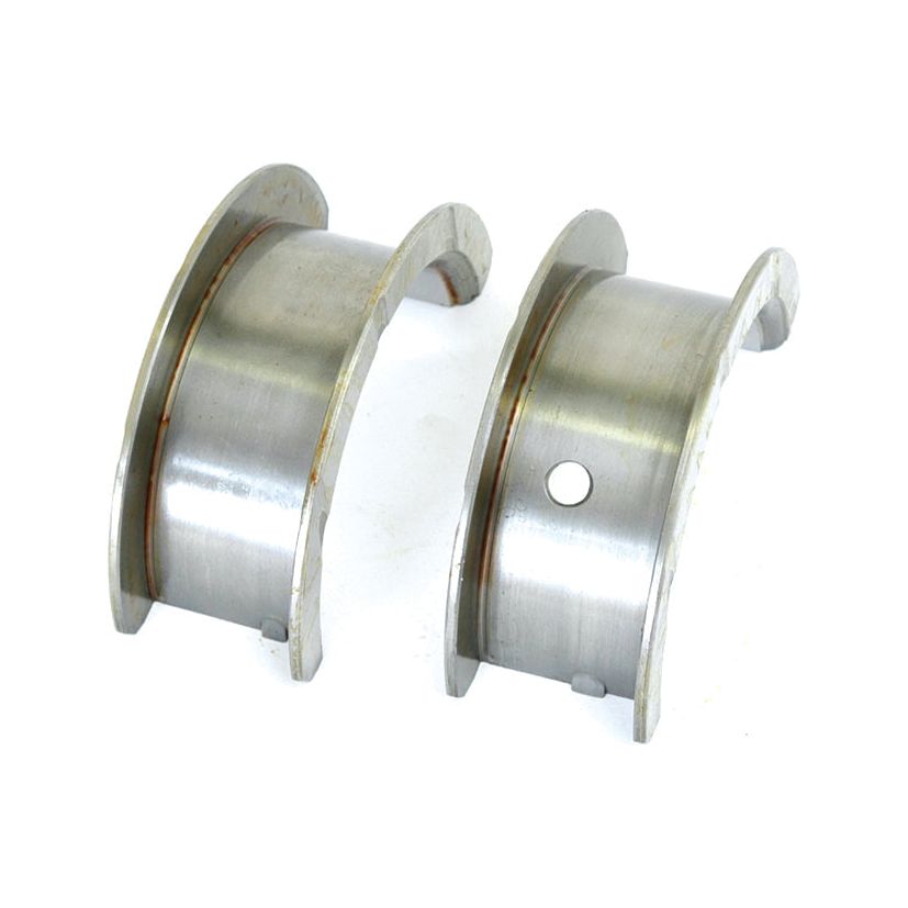 Two metallic bearing shells, each with a curved shape, are shown side by side. One shell features a circular hole, while the other does not. These Main Bearing STD | Sparex Part No. S.31640 components from the brand Sparex are crucial in mechanical assemblies and can include integral thrust washers for enhanced performance, commonly found in John Deere machinery.