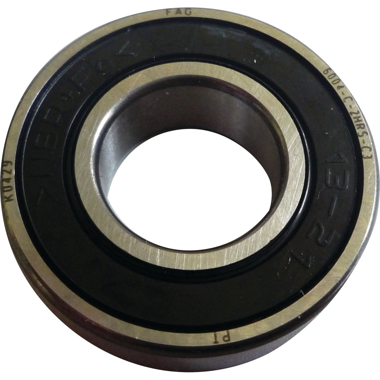 Close-up of a single metal ball bearing with inner and outer raceways, marked "Sparex" and product code "S.146131 6001.C.2HRS.C3". The Sparex Spigot Bearing has a black seal on both sides.