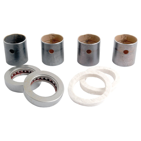 The image shows four metal cylindrical bearings, two metal circular seals, and three white circular gaskets arranged on a plain background, reminiscent of components from the Spindle Repair Kit (Sparex Part No. S.17501) by Sparex.
