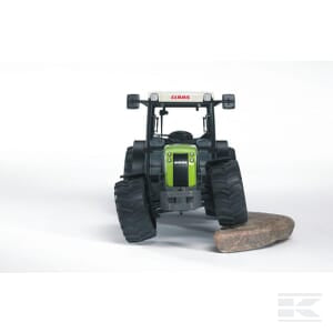 Positioned on a white background, the Bruder Claas Nectis 267 F - U02110 toy tractor, featuring large black tires and a green and black body, embodies the essence of modern agriculture with a small brown rock under its right front tire.