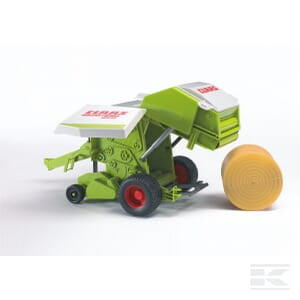 A green and white Claas agricultural machine, the Bruder Claas round baler - U02121, is shown baling hay with a yellow hay bale beside it. This 1:16 scale model features red wheels and precisely captures the intricate details of the Tracer.