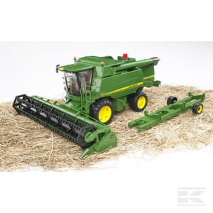 A John Deere Combine Harvester T670i - U02132 by Bruder, in striking green and yellow, sits on a bed of straw next to its header attachment, embodying the essence of modern agriculture.