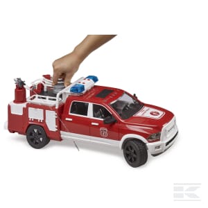 A person is placing a metal cylinder into a Bruder RAM 2500 Fire engine truck with L+S Module - U02544, featuring black wheels and emergency lights on top.