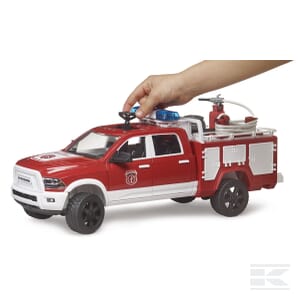 A hand interacts with a 1:16 scale RAM 2500 fire engine truck from Bruder, model U02544, which is red with a white top, black wheels, and features a firefighting equipment compartment on the back.