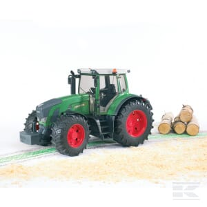 A Bruder Fendt 936 Vario - U03040 tractor with its distinctive green body and large red wheels is parked on a surface covered with scattered wood shavings, next to a small stack of cut logs, exemplifying its robustness and significance in agriculture.