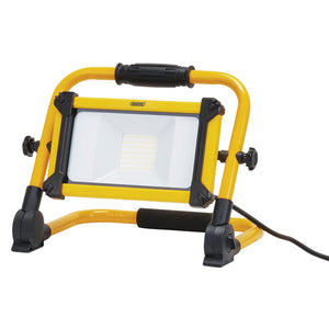 Yellow and black Draper 110V Smd LED Folding Site Light, 10W, with a stand, power cord, IP65 IK06 rating for industrial use providing 1100 lumens - Model: 110V/FSL/10W.