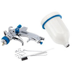 The Draper Gravity Feed HVLP Air Spray Gun, 600ml - GSG5-600, features an adjustable flow for precision painting and comes with an attached white paint cup. It is accompanied by two metal tools and a small black piece. The durable aluminium body ensures ease of handling.