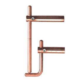 Copper pipe fittings arranged to resemble the letter "F", positioned alongside a sturdy Sealey Spot Welding Arms 120mm Exterior Profiles - 120/803158.