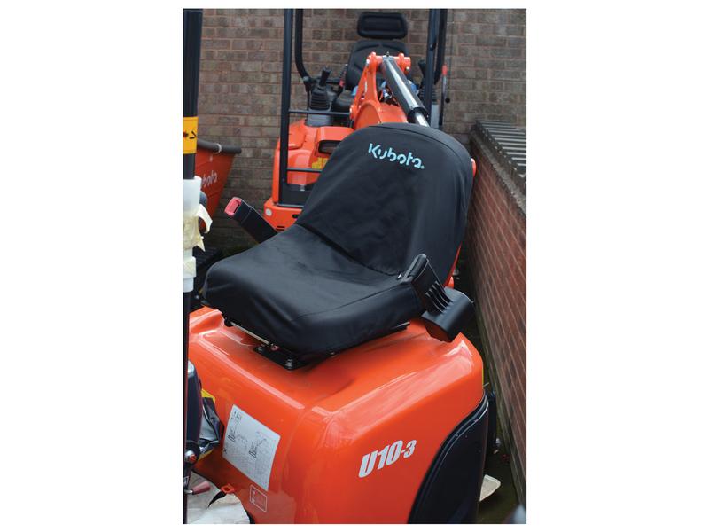 An orange Kubota U10-3 mini digger featuring a Sparex S.127942 waterproof black seat cover, weighing 0.58kg, is parked near a brick wall.