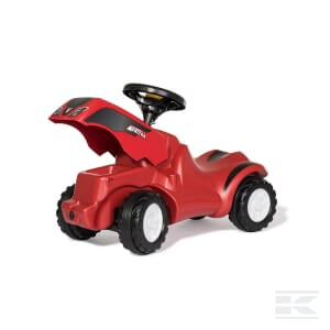 A red Push Tractor, Valtra - R13239 by Rolly Toys, featuring a raised seat, steering wheel, and black and white plastic wheels, viewed from a rear angle, next to a Rolly Kipper toy trailer.