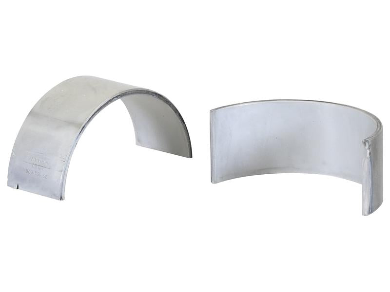 Two shiny, metallic bearing shells are shown. One is viewed from the side, revealing its curved surface, while the other is viewed partially end-on, showing its interior. These Conrod Bearing +0.020'' (0.50mm) pairs (Sparex Part No.S.163328) are ideal replacements for Deutz-Fahr AGROTRON series and are supplied by the trusted brand Sparex.
