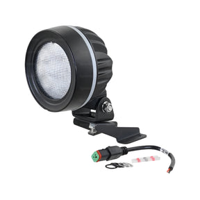 The John Deere Fendt LED Work Light by Sparex, model S.163896, is a round, black work light with a ridged casing. It features a flood beam design and comes equipped with a mounting bracket and an attached power cable with a green connector. Designed to operate efficiently at 10-30V, this light includes screws and washers for easy installation. It offers 4950 lumens raw output and meets interference Class 5 standards.