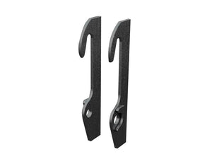 Two black metal Loader Brackets (Pair) with a curved top and a hole near the bottom stand upright side by side against a white background, showcasing their impressive thickness. This product is a replacement for Schaffer and has the Sparex Part Number: S.167839.