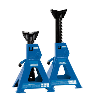 The Draper Ratcheting Axle Stands, 3 Tonne (Pair) - AS3000R from Draper include two blue jack stands with a lifting capacity of 3000 kg each. One stand features an extended height via ratchet-type action and a large saddle, while the other remains in its lowered position.