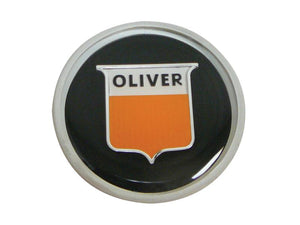 A circular steering wheel cap featuring the word "OLIVER" above an orange shield-like emblem on a black background, brought to you by Sparex (Sparex Part Number: S.65619).