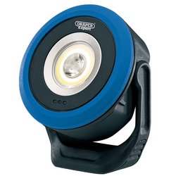 A blue and black Draper Cob/Smd LED Wireless/USB Rechargeable Mini Flood Light (WL/MFL670) with a handle, suitable for various lighting tasks. The circular 7W COB LED element, producing 670 lumens, is encased in the center. The brand name "Draper Expert" is visible on top, and it comes with a USB-C charging cable for added convenience.