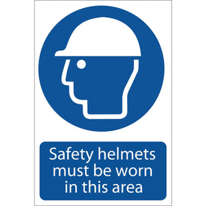 Draper Safety Sign - SS01, featuring a white helmet icon on a blue circle and the text "Safety helmets must be worn in this area," is printed using UV resistant ink for durability and adheres to the BS5499 Standard.