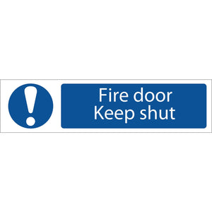 A Draper Fire Door Keep Shut - SS61 UV resistant sign in blue and white, featuring an exclamation mark on the left and text on the right reading "Fire door Keep shut.