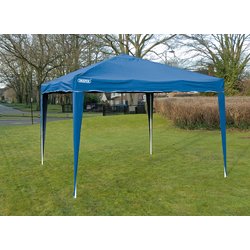 The Draper Concertina Gazebo, 3 x 3M in blue (GAZ2), made of durable splashproof material, is set up on a grassy area with trees and houses visible in the background. Perfect for both commercial and domestic projects, this easy-to-assemble gazebo combines functionality with convenience.